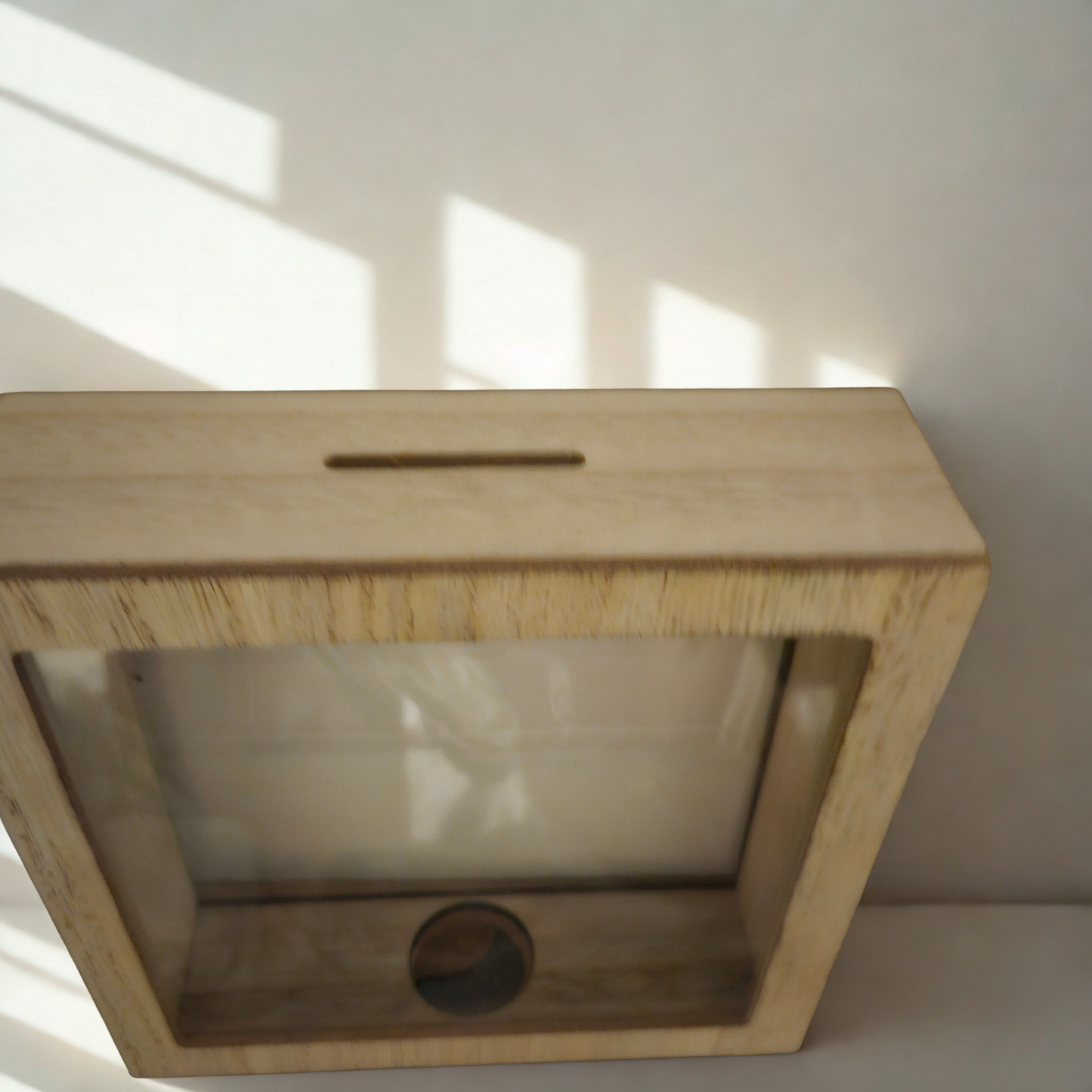 Spardose aus hellem Holzrahmen